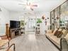 Living area featuring ceiling fan and light inished floors