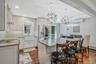 Kitchen featuring appliances with stainless steel finishes, a breakfast bar area, dark wood-type flooring, tasteful backsplash, and pendant lighting