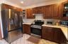 Kitchen featuring glass insert cabinets, appliances with stainless steel finishes, light countertops, light tile patterned floors, and recessed lighti