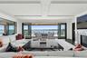 Living area with a water view, a premium fireplace, wood finished floors, plenty of natural light, and recessed lighting