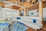 Living area featuring wood-finish flooring, exposed wood beam ceiling, and skylights