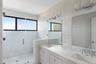 Full bathroom with double vanity, a stall shower, and a sink