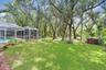Expansive backyard with mature oak trees which includes fruit trees - mango, Florida apple and banana trees.