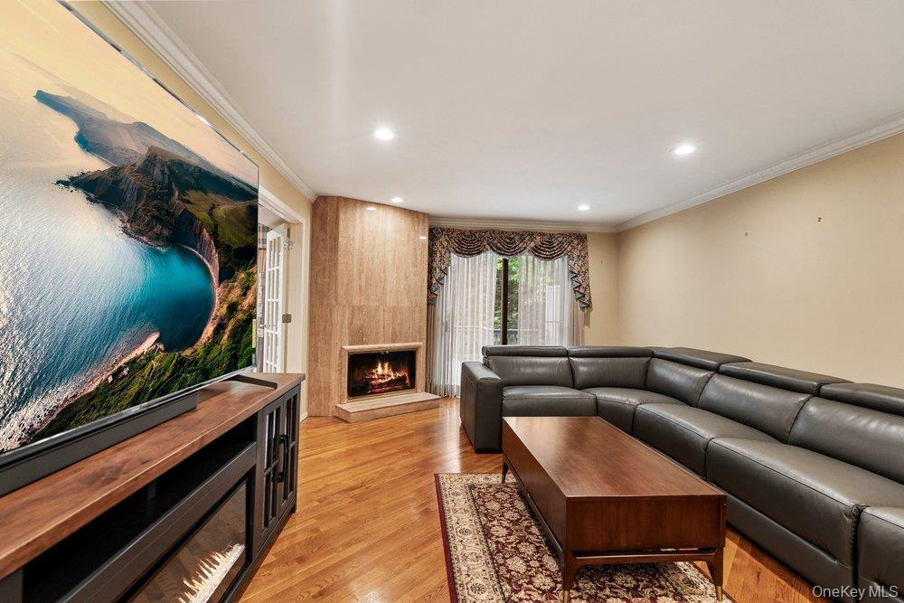 Living area featuring hardwood flooring, recessed lighting, and crown molding