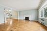 Unfurnished living room featuring radiator, healthy amount of natural light, decorative columns, and ornamental molding