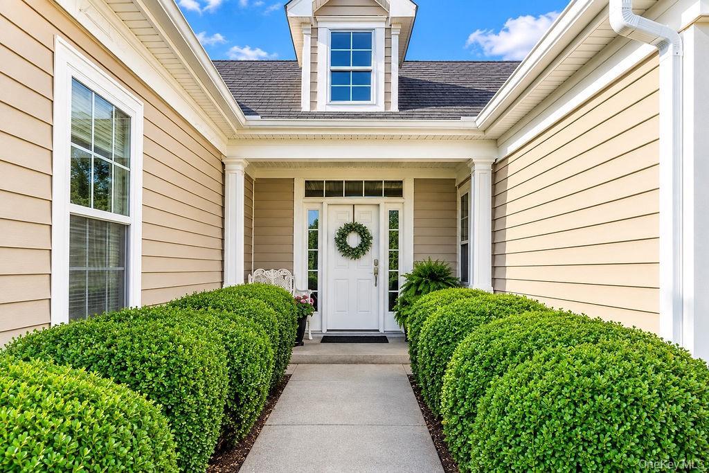 Covered entry framed by manicured Boxwoods