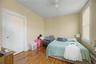Sloped ceiling room featuring wood-finish flooring, a double window, and a flush-mount light fixture