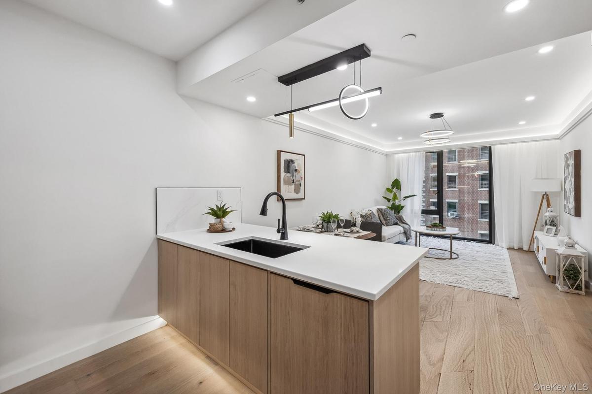 Kitchen with a sink, modern cabinets, a peninsula, light wood-type flooring, and recessed lighting