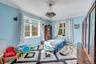 Bedroom featuring multiple windows, ornamental molding, and a baseboard radiator