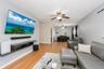 Open-concept living area featuring wood-finish flooring, light gray walls, and multiple ceiling fans
