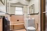 Bathroom featuring tile walls, toilet, a wainscoted wall, vanity, and shower / bath combo with shower curtain