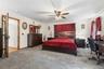 Spacious room featuring neutral carpeting, white walls, and a ceiling fan with integrated lighting