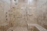 Close-up of the oversized spa-inspired shower showcasing elegant tile work and sleek modern finishes.