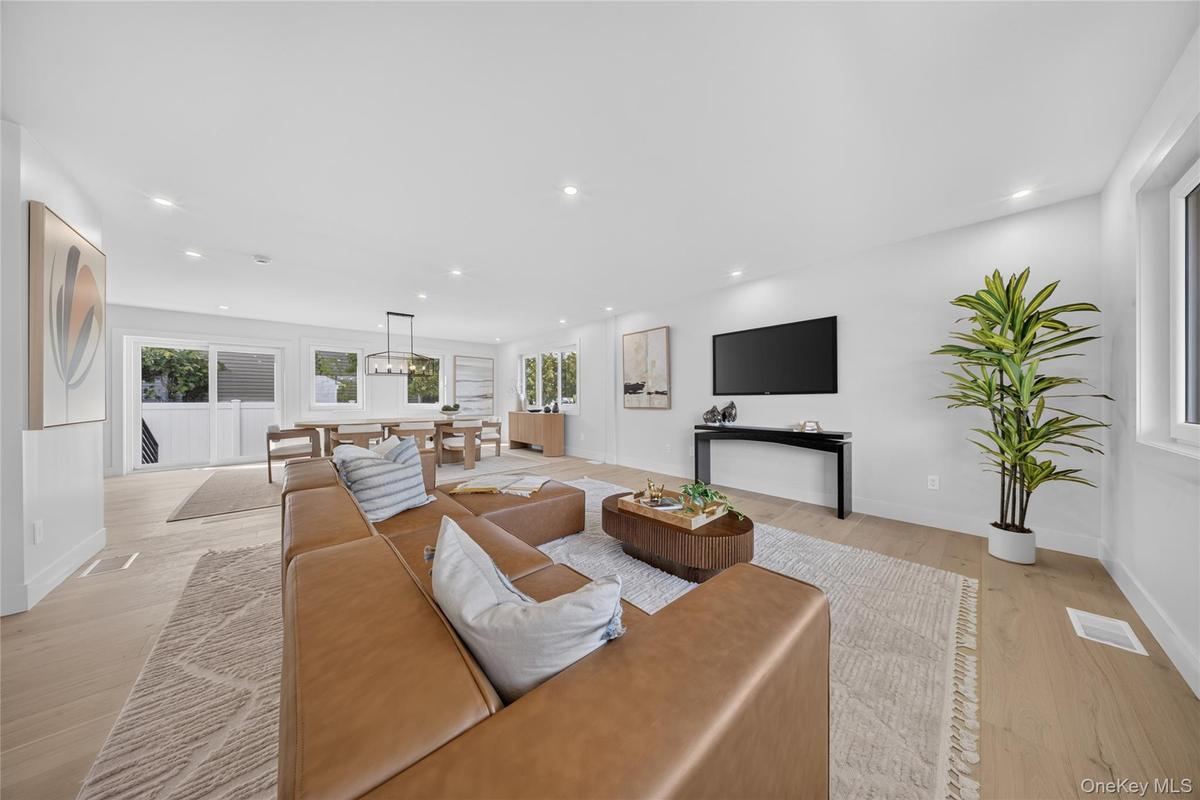 Open-concept living area featuring wood-finish flooring, recessed lighting, and expansive windows