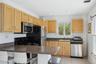 Kitchen featuring a sink, dark countertops, visible vents, light brown cabinets, and appliances with stainless steel finishes