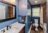Hall Bathroom featuring a white vanity with a rectangular sink, bronze-finish faucet, and a large framed mirror