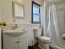5 - Full bath featuring vanity, toilet, wainscoting, and a shower with curtain