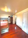 Master Bedroom with dark wood finished floors and baseboards