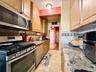 Well maintained kitchen, with light oak cabinets, granite countertop, tiled backsplash.