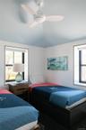 Bedroom featuring multiple windows and a ceiling fan