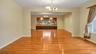 Unfurnished dining area featuring an inviting chandelier, baseboards, and light wood finished floors