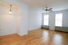 Empty room with light wood-style flooring, radiator, and ceiling fan