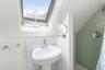 Full bathroom with tile walls, a tile shower, and a skylight