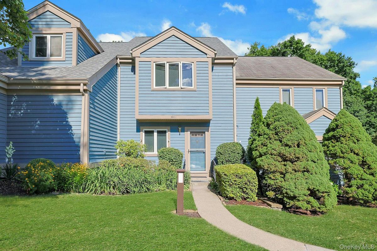 Blue siding exterior with contrasting trim accents and beautiful landscaping. The roof is less than 5 years old