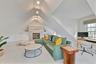 Carpeted living room with built in shelves, an office area, and lofted ceiling