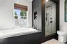 Primary Bathroom – Luxurious primary bathroom featuring a deep soaking tub, spacious glass-enclosed walk-in shower, contemporary tile finishes, and a 