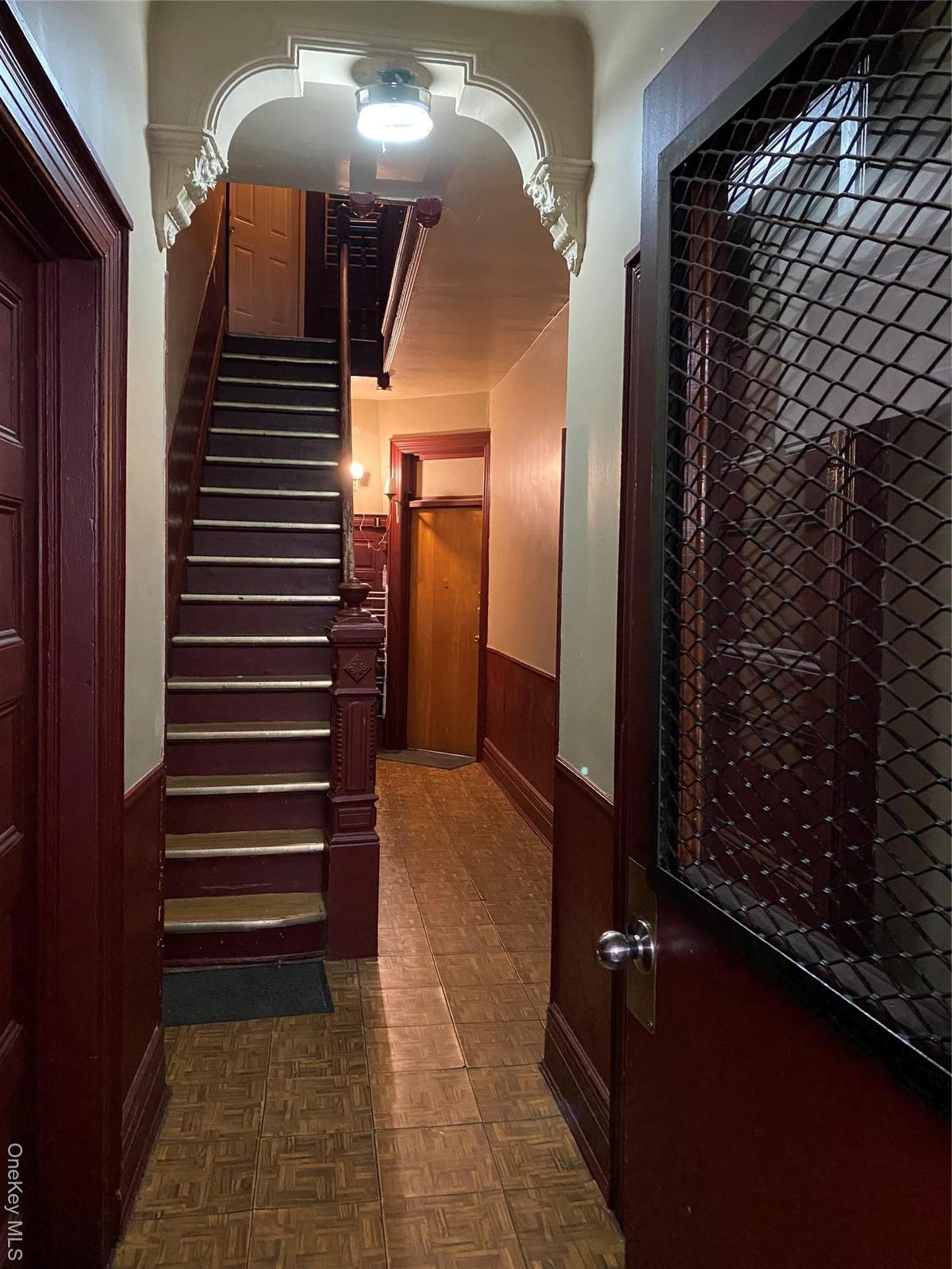 Staircase with wainscoting and wooden walls