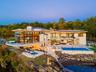 Back of property with a patio area, a swimming pool with hot tub, and a water view