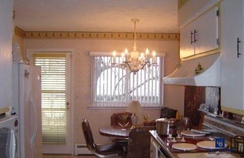 Dining area featuring a baseboard heating unit and a chandelier