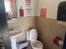 Bathroom featuring toilet and tile walls