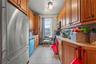 Kitchen with stainless steel appliances, light countertops, light tile patterned flooring, and brown cabinets