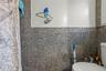 Bathroom featuring toilet and tile walls
