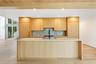 Kitchen featuring a large island, light countertops, light brown cabinets, recessed lighting, and expansive windows