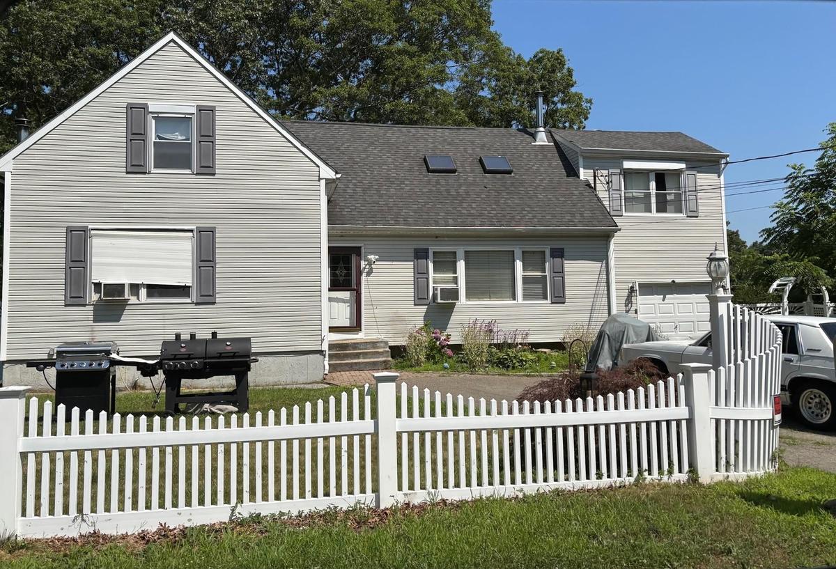 Traditional-style home featuring a shingled roof and an attached garage