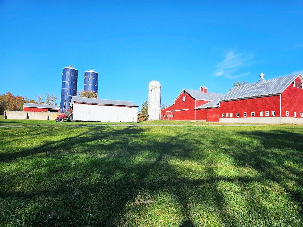 View of farm featuring barns, silos and a pole building