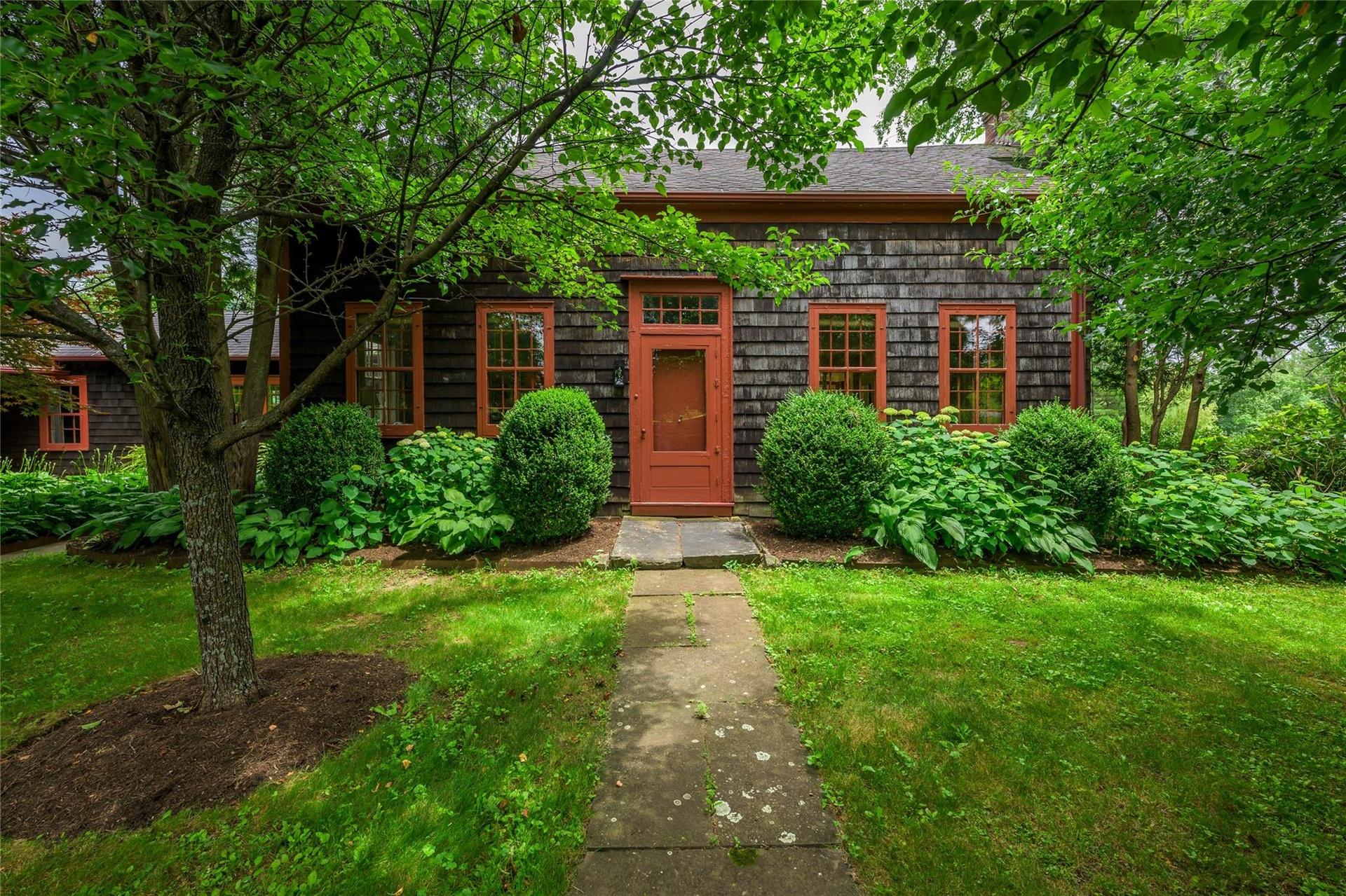 View of front of property featuring a shingled roof and a front yard