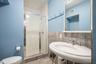 Bathroom featuring a shower stall and tile walls