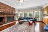 Living room featuring hardwood / wood-style flooring, crown molding, a brick fireplace, recessed lighting, and a chandelier