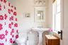 Full bathroom featuring a wainscoted wall, toilet, a shower with curtain, and a sink