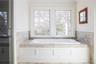 Bathroom with a garden tub and crown molding