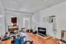 Living room featuring a textured ceiling, a baseboard heating unit, and wood finished floors