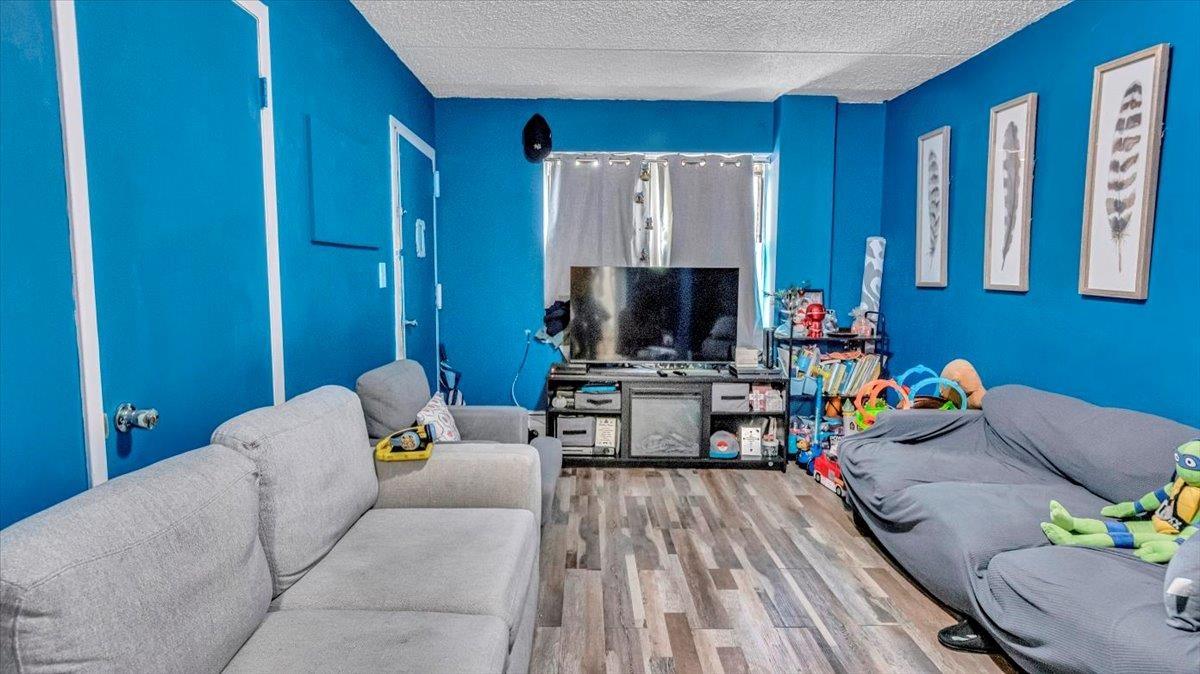 Living room with a textured ceiling and wood finished floors