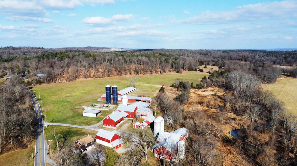 Bird's eye view of farm with a view of field & woods