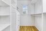Walk in closet with wood finished floors