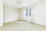 Spare room with light colored carpet, a ceiling fan, and baseboards