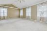 Unfurnished room featuring ceiling fan, plenty of natural light, lofted ceiling, and carpet floors
